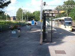 Looking along the platform towards Manchester as a tram to Bury heads off